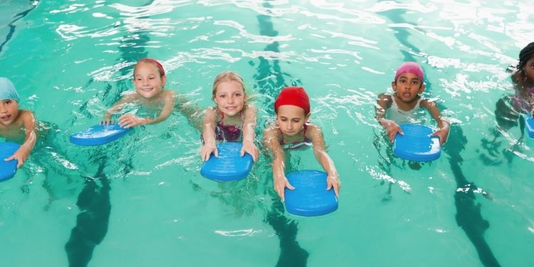 Several children learning to swim