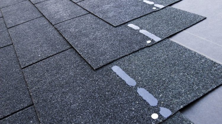 rows of asphalt shingles showing layers and glue